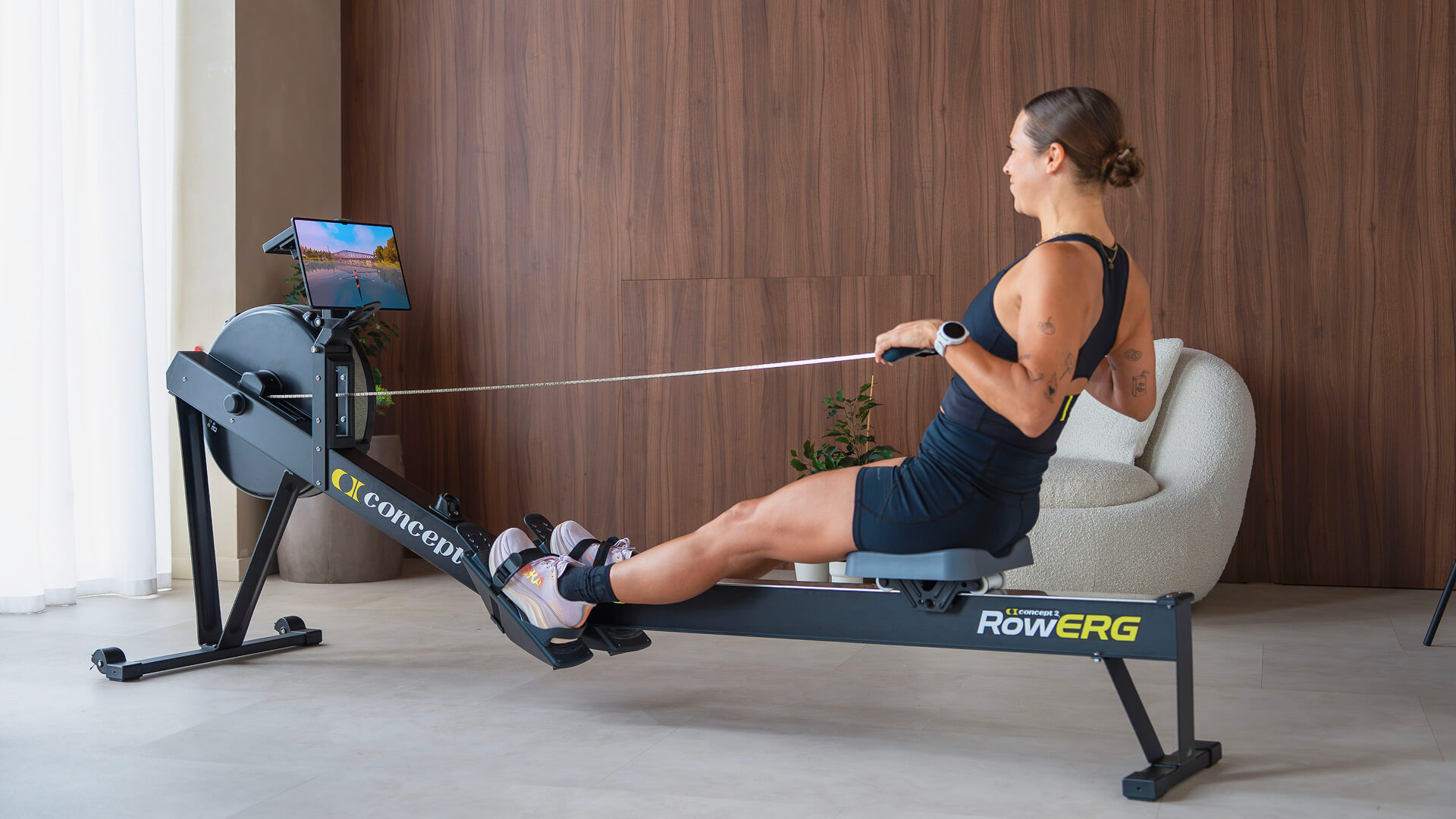Woman rowing on a Concept2 RowErg with the EXR app.
