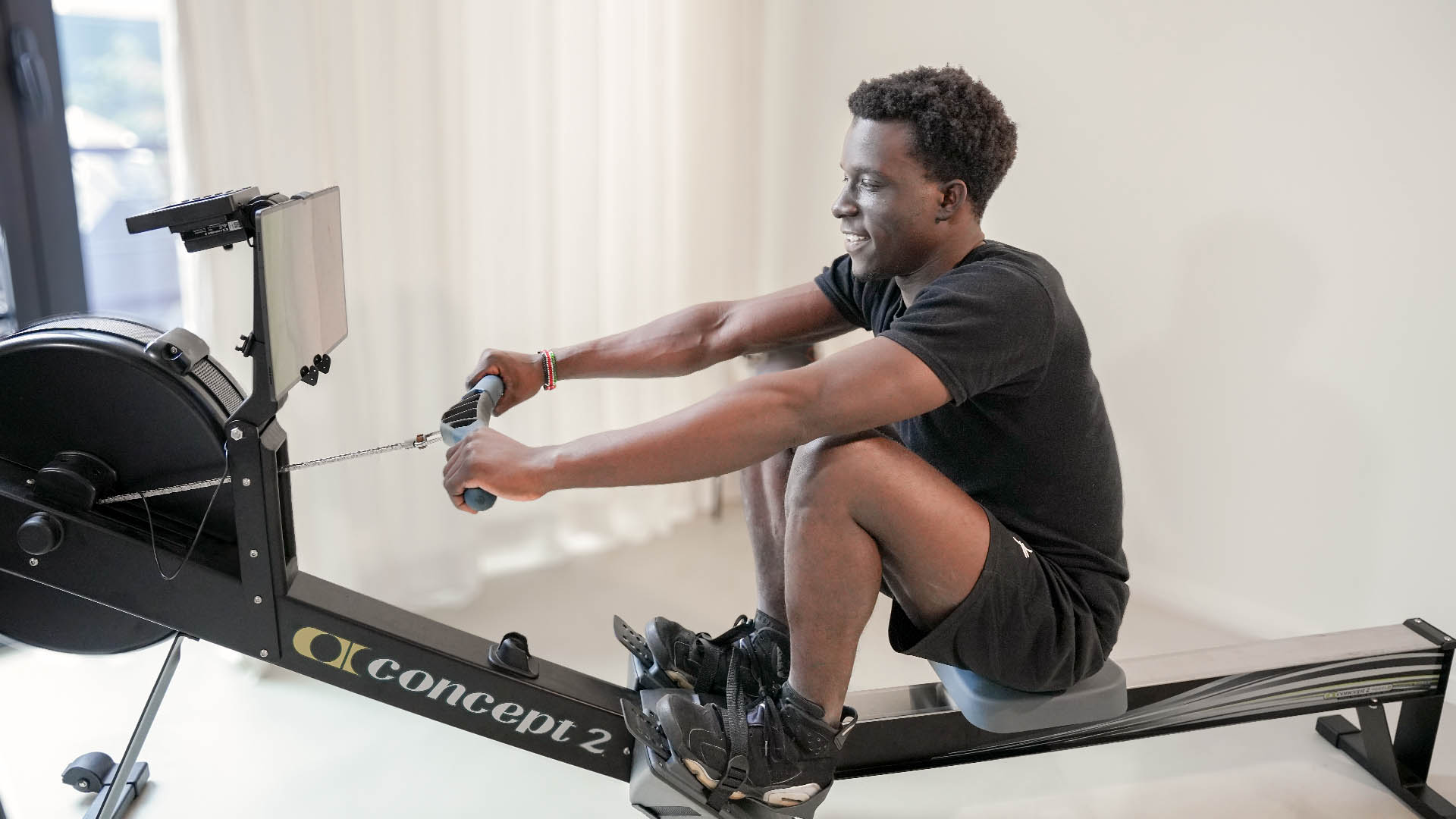 Man rowing in his living room.