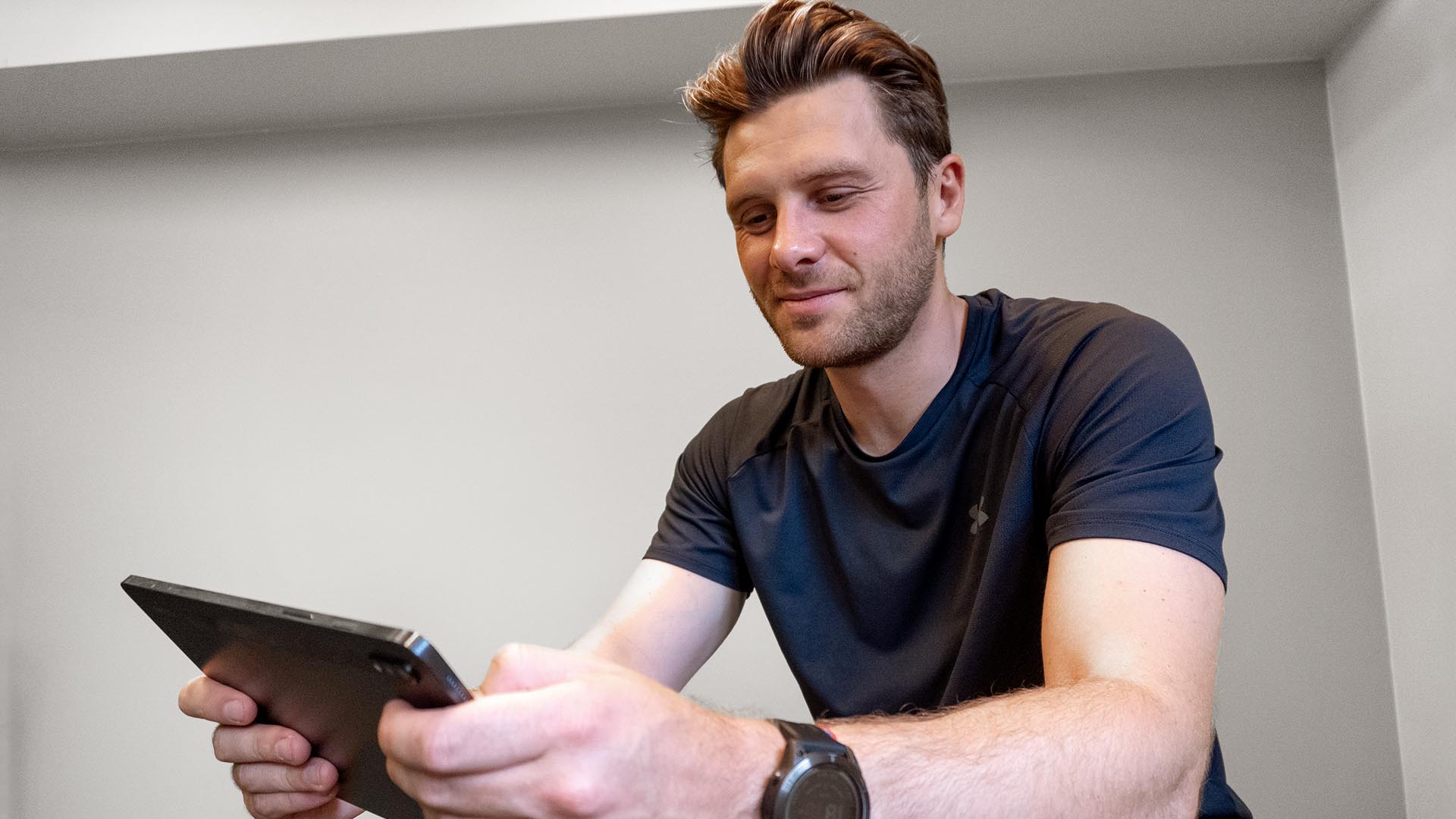 Man looking at his tablet to analyze his rowing performance.