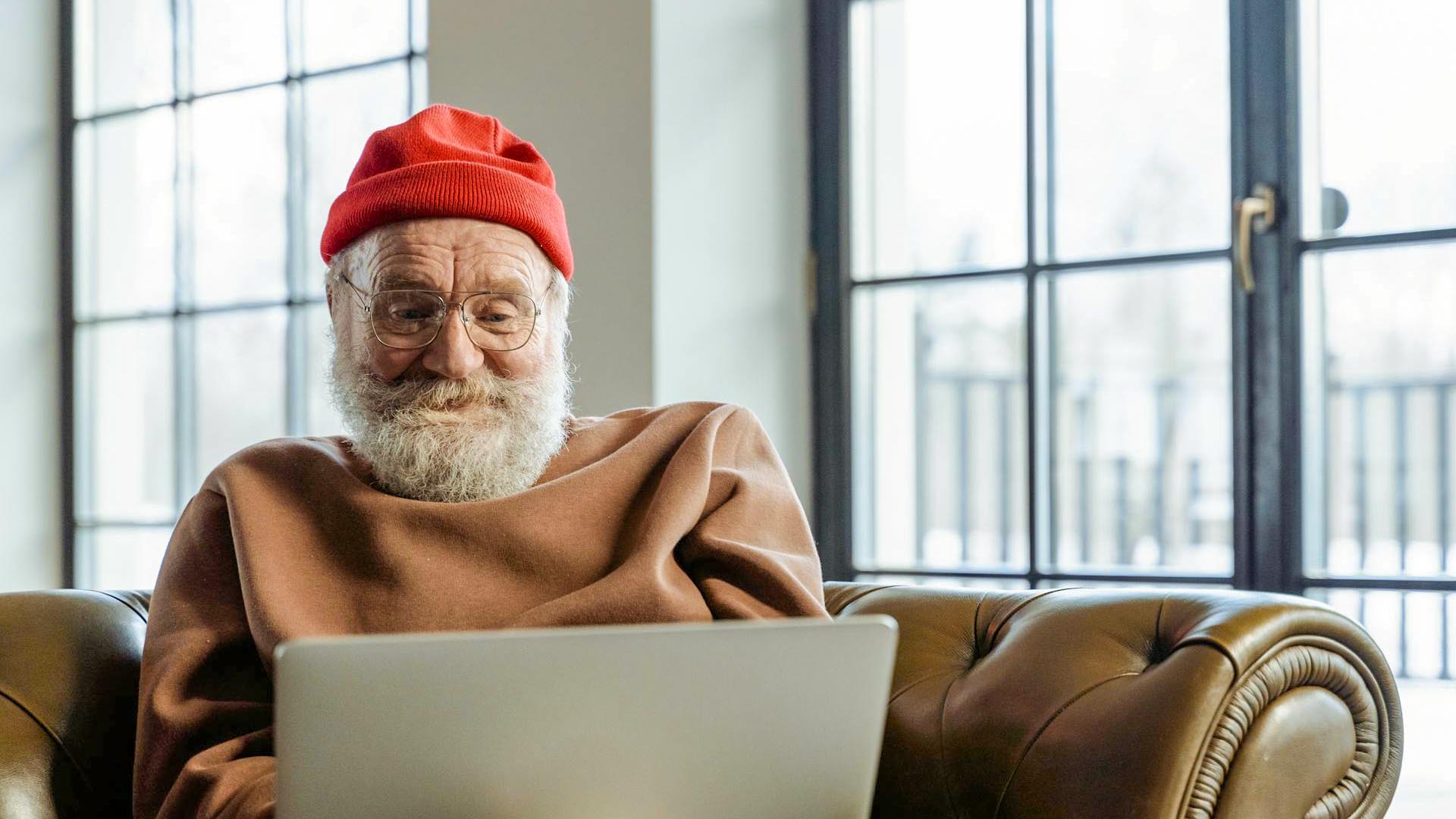 Old man reading on laptop