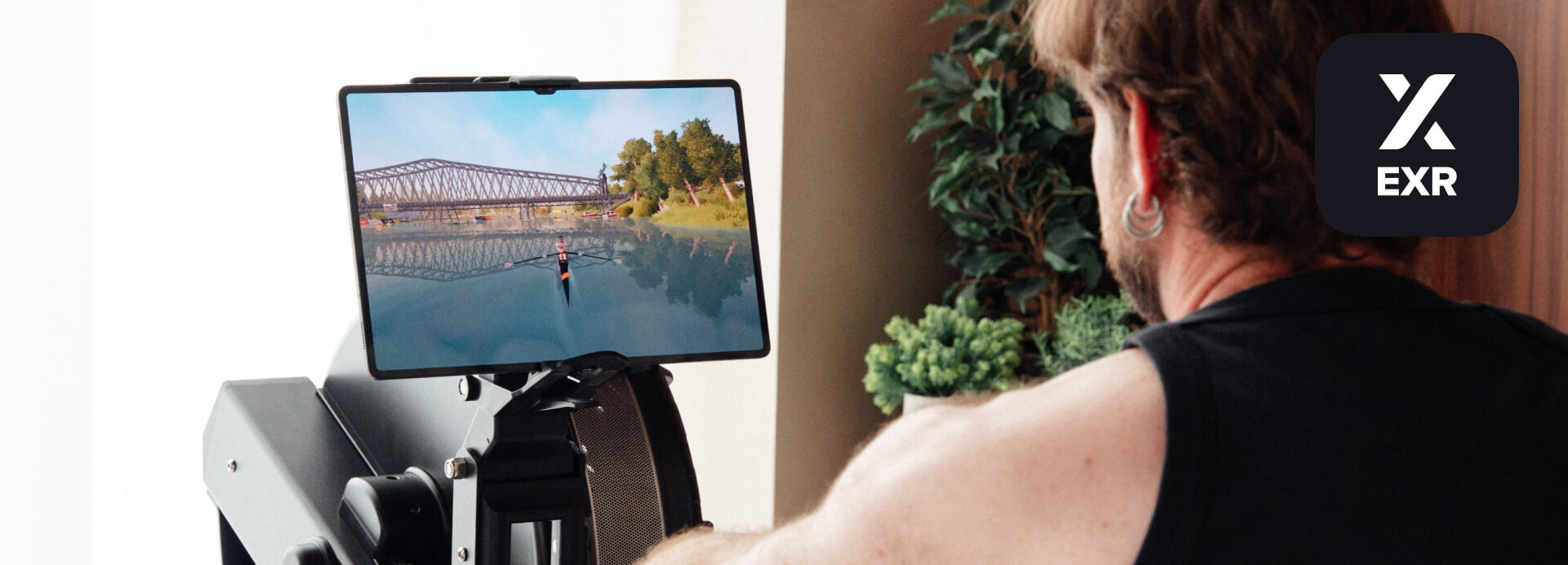 Rower using EXR on a Concept2 RowErg with an immersive virtual rowing environment displayed on a screen