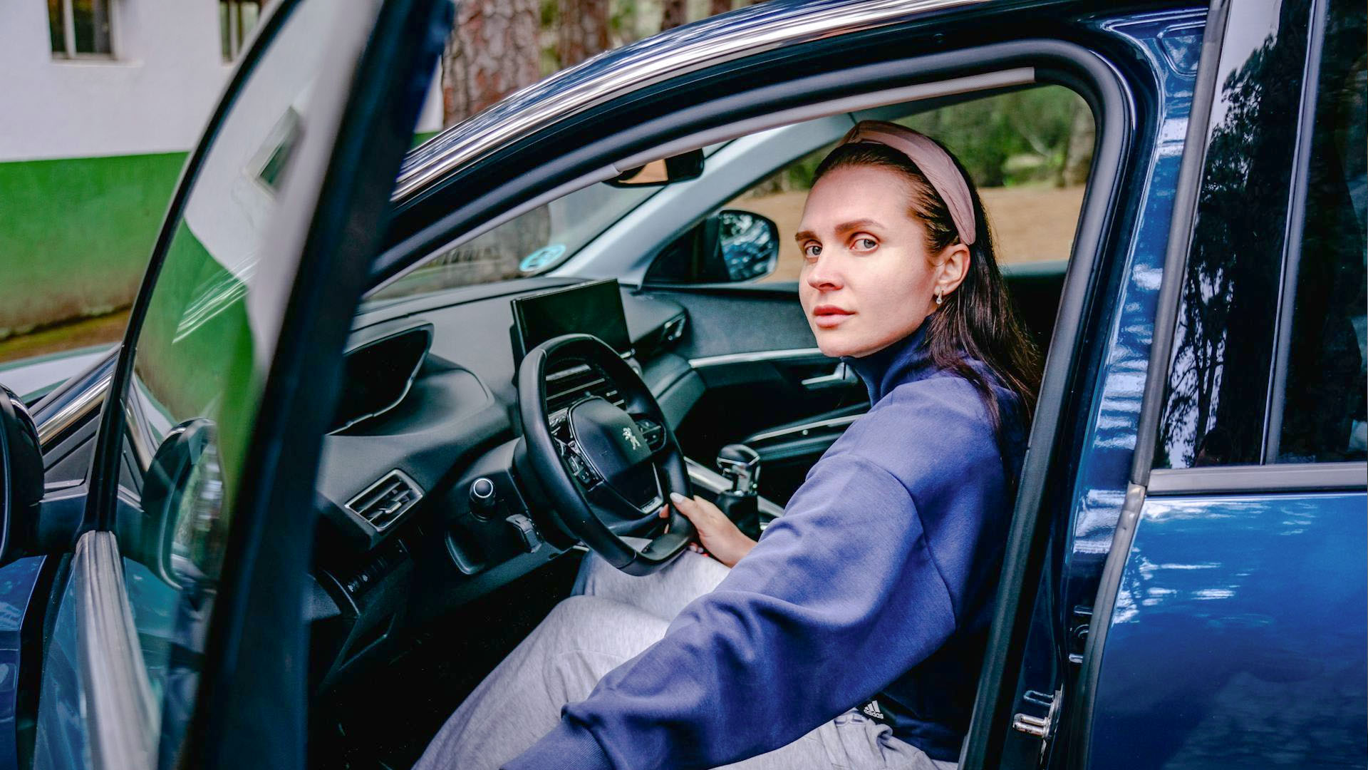 Woman in sport clothes driving a car.