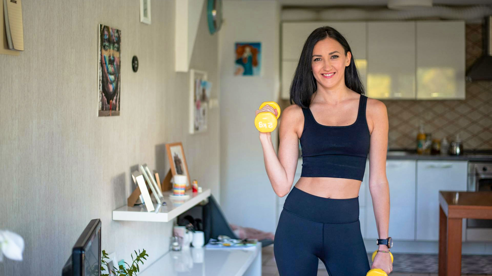 Woman using weights to train in her living room.