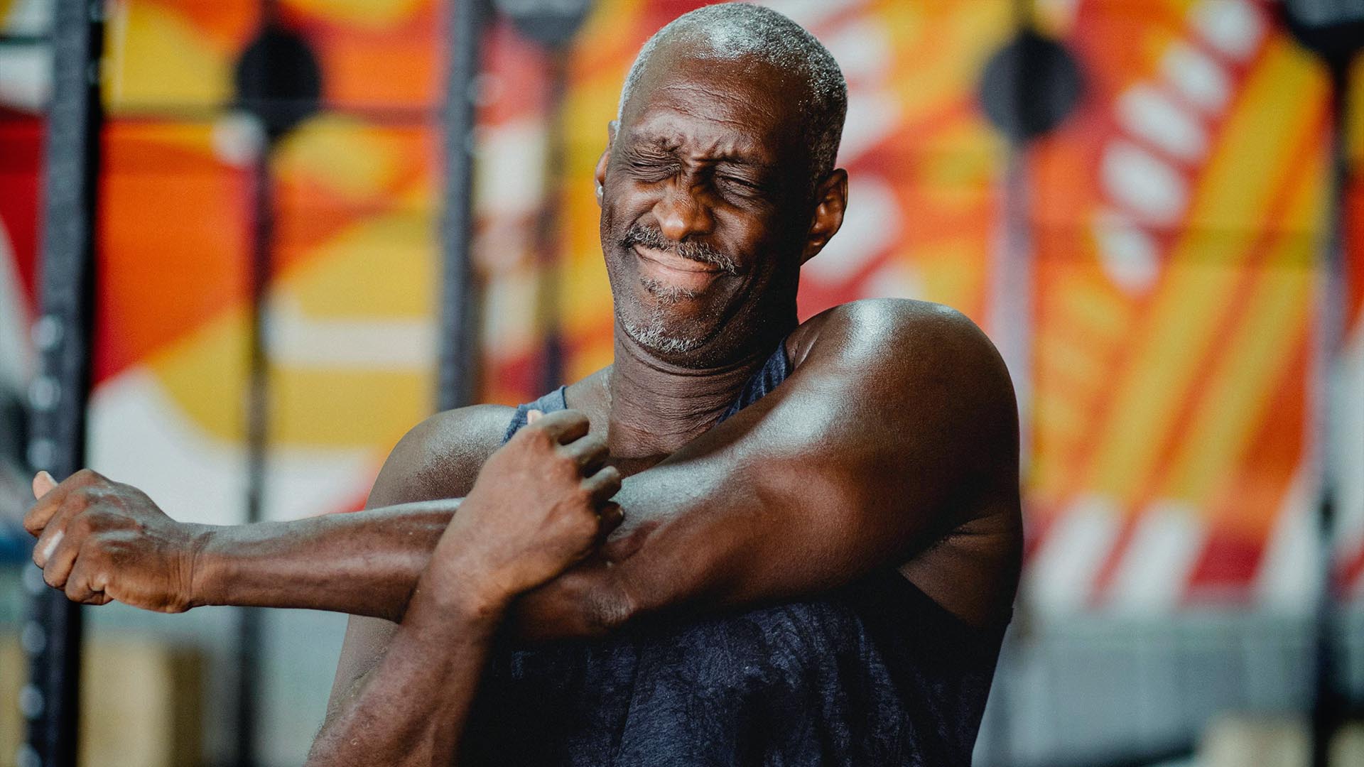 Man stretching his arm in the gym.
