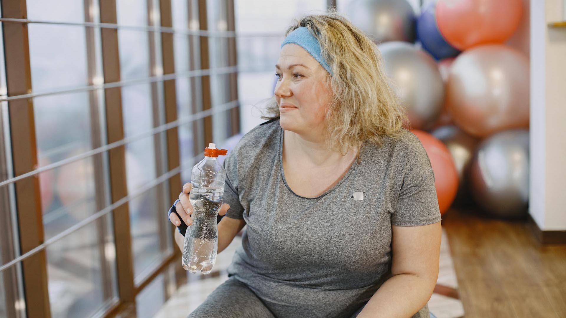 A woman sitting and taking a break from her workout.