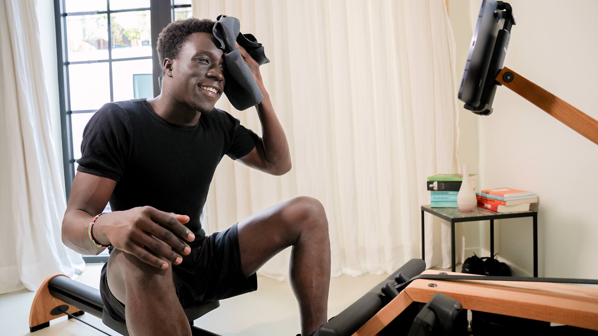 woman using an indoor rowing machine during a fat-loss focused workout session. The image highlights indoor rowing as a low-impact, full-body exercise suitable for weight loss and improving fitness.