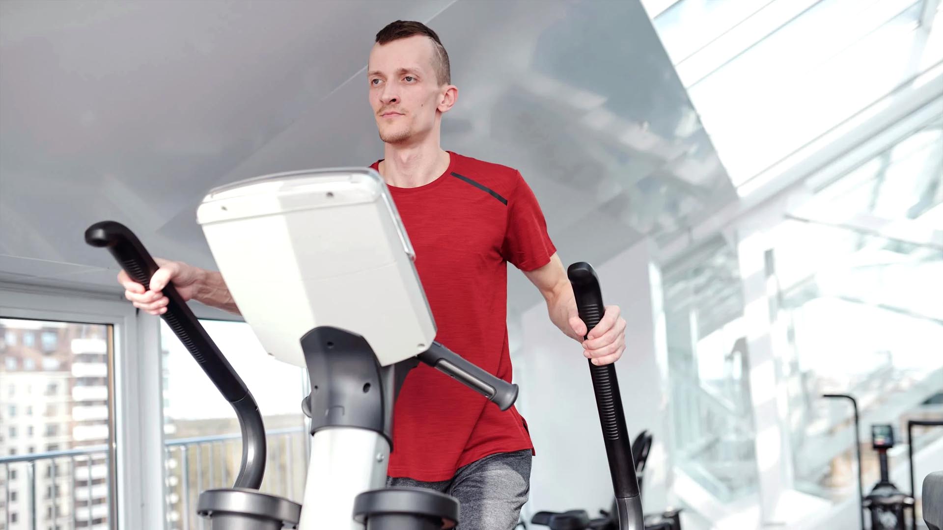 Man training on an elliptical training tool at the gym.
